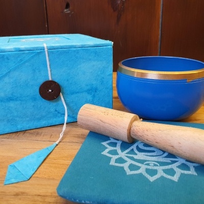 Conjunto de tigela azul com pau de madeira, pano azul e caixa azul com botão