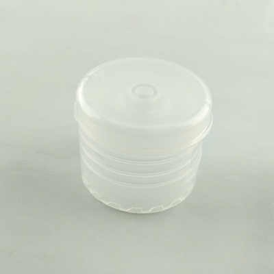 Tampa de plástico translúcido branca sobre superfície cinza