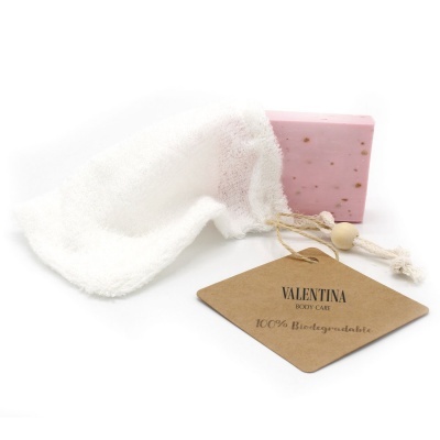 Sabonete rosa com bolsa de tecido branco e etiqueta biodegradável