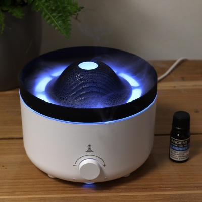 Difusor de aromas branco com luz azul e frasco de óleo essencial