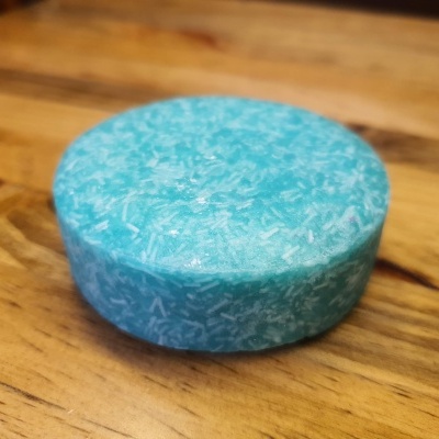 produto redondo azul com riscos brancos sobre superfície de madeira