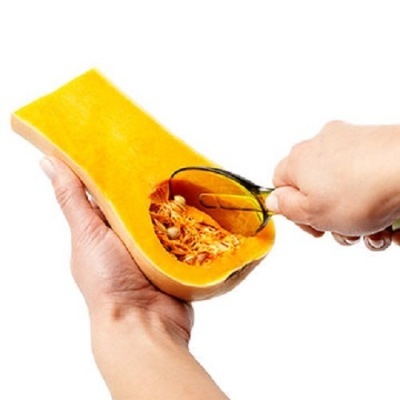 Abóbora a ser limpa com utensílio metálico