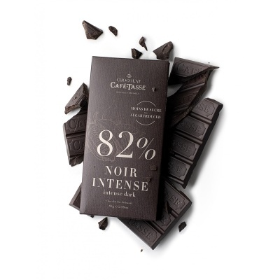 Barra de chocolate negro Cafétasse 82% cacau com embalagem preta e pedaços partidos