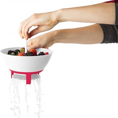 Escorredor branco com frutas e suporte vermelho a escorrer água