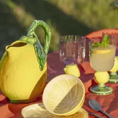 Conjunto de loiça cerâmica em forma e padrão de limão sobre toalha laranja