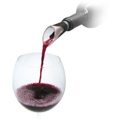 Vinho tinto a ser vertido numa taça de vidro com acessório metalizado