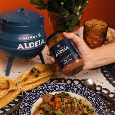 Frasco COLINHA ALDEIA VITELA À MADEIRA com comida em prato azul e branco sobre mesa decorada
