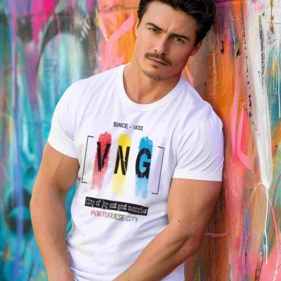 Homem de camisa branca estampada encostado em parede grafitada colorida