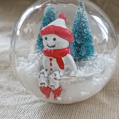 Bolinha de Natal transparente com boneco de neve e árvores
