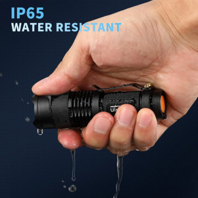 Lanterna preta resistente à água IP65 com botão laranja e clip de metal, segurada por mão molhada