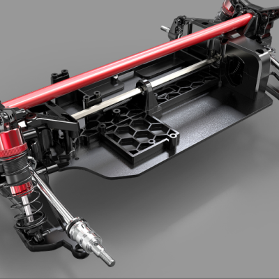 Chassis de modelo RC preto com amortecedores vermelhos sobre fundo cinzento.