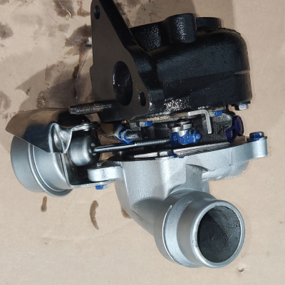 Turbina automóvel metálica cinzento prateado e preto com parafusos azuis em fundo castanho