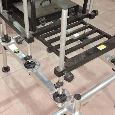 Estrutura metálica regulável com plataforma de barras pretas em chão de azulejos