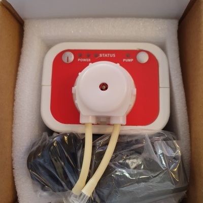 Dispositivo elétrico com painel vermelho e cabos em caixa de cartão