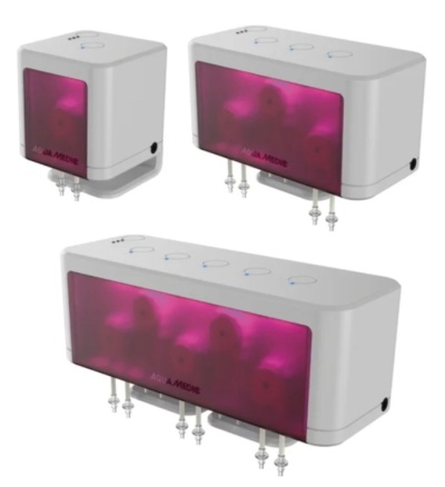 Três dispensadores médicos brancos com tampas roxas transparentes com texto AQUA MEDIC e válvulas metálicas em fundo branco