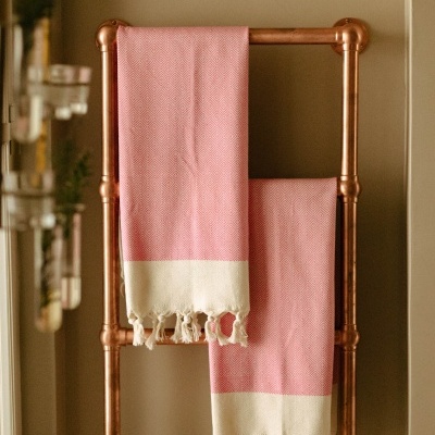 Escada cobre com fatos de banho rosa e branco pendurados