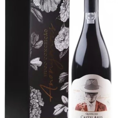 Garrafa de vinho tinto ao lado de caixa preta com ilustrações de flores.