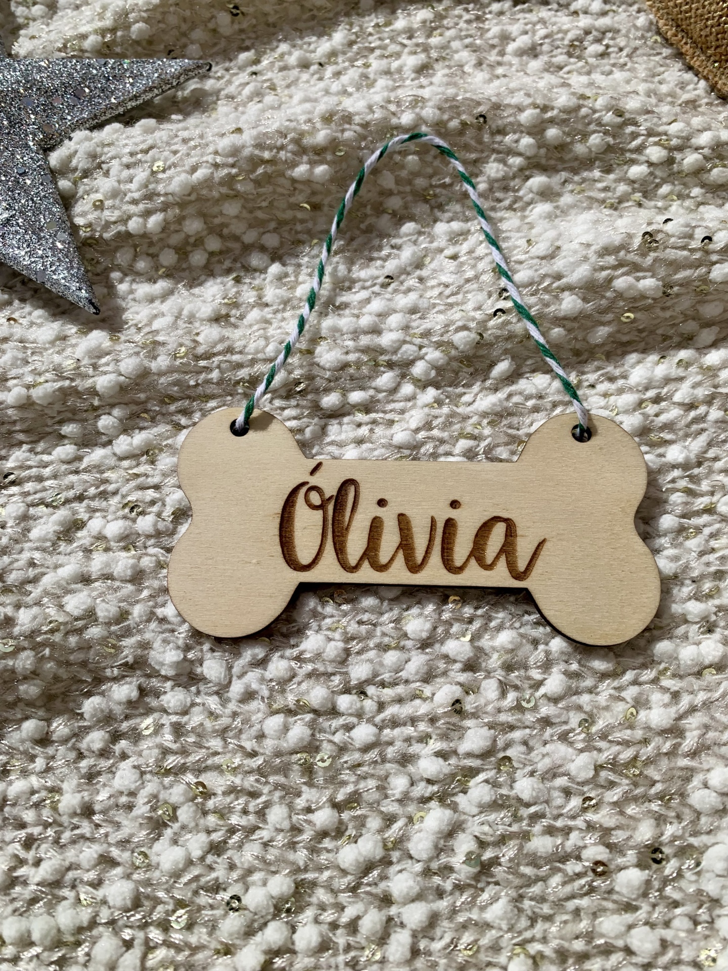 Etiqueta de madeira em forma de osso com o nome Olivia gravado