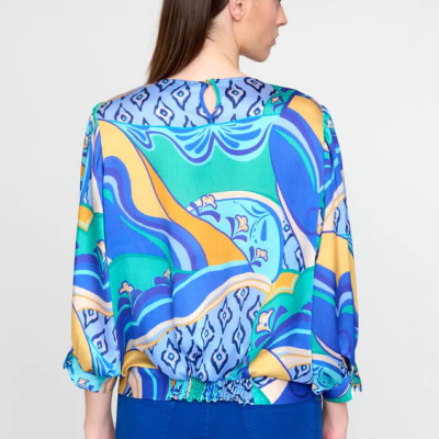 Blusa feminina colorida com padrão abstrato em tons de azul, amarelo e verde vista de costas