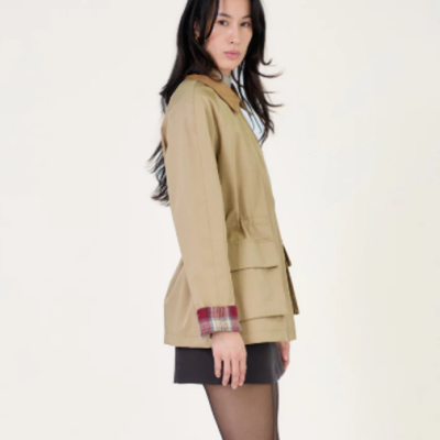 Casaco bege com bolsos e forro xadrez em modelo feminino