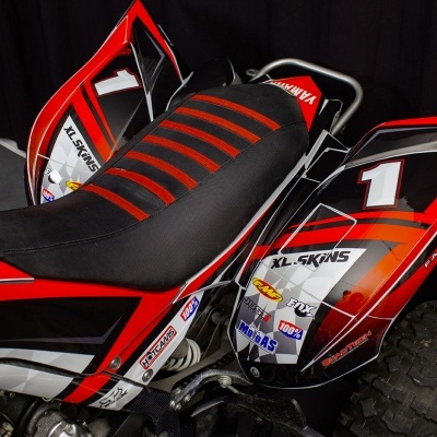 Quadriciclo vermelho, preto e branco com número 1 no painel lateral