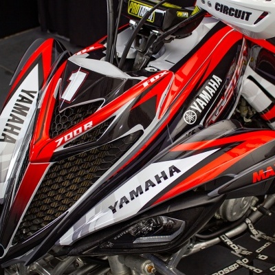 Quad Yamaha vermelho, preto e branco com texto e pneus todo terreno
