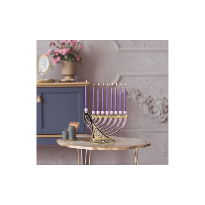 Menorá dourada com velas roxas acesas sobre mesa redonda de mármore