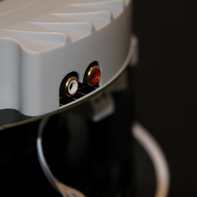 Aparelho eletrónico cinzento com entradas áudio RCA branca e vermelha