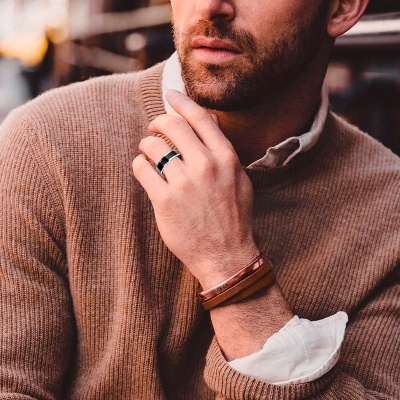 Homem com anel prateado e bracelete de couro castanho