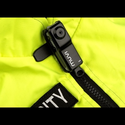 Câmara MUVI fixada num casaco amarelo com fecho preto e etiqueta 'SECURITY'