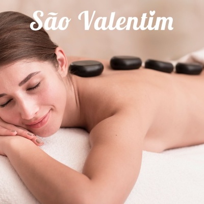 Mulher deitada para massagem com pedras quentes e texto São Valentim