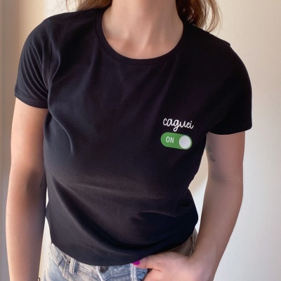 T-shirt preta com texto 'caguei ON' em branco e verde
