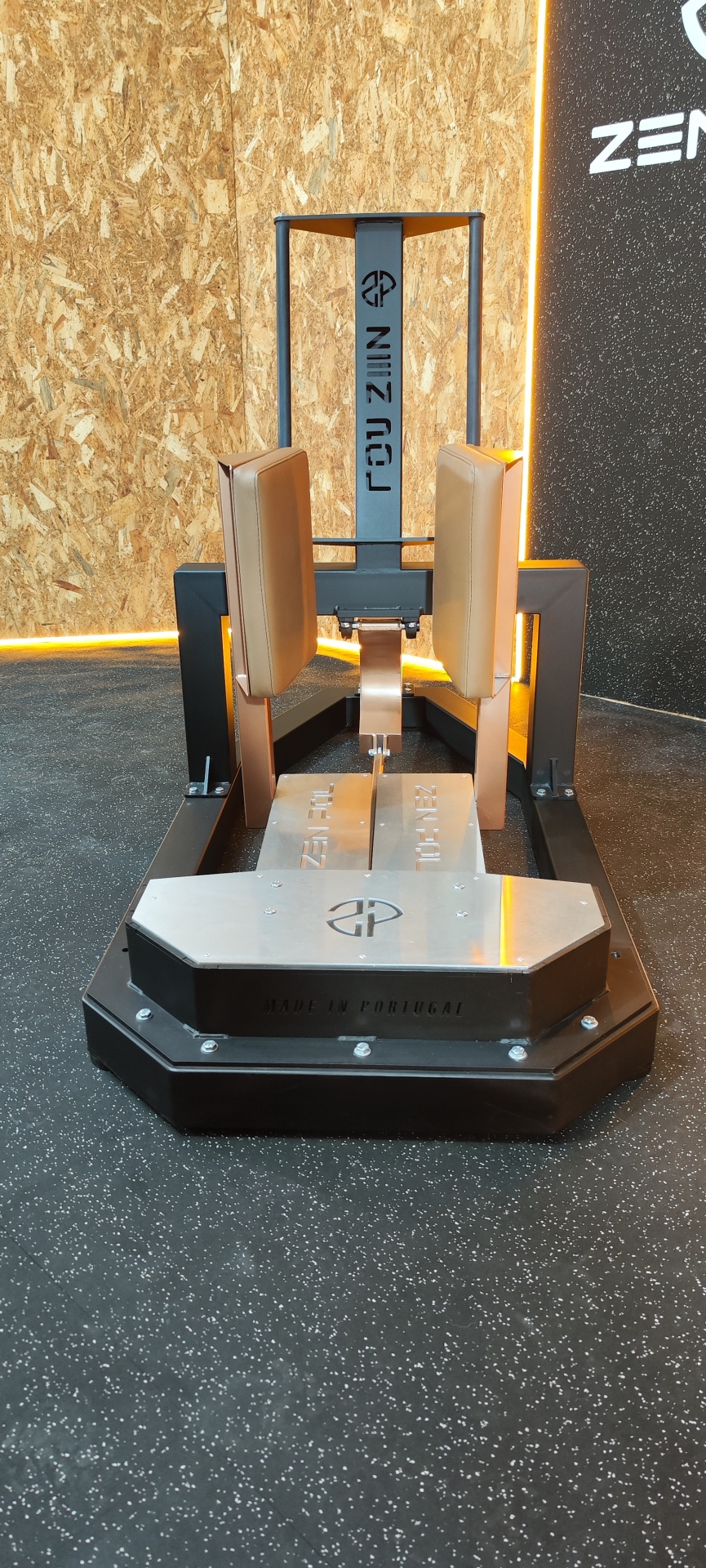 Máquina de exercício de musculação em metal com estofos castanhos.