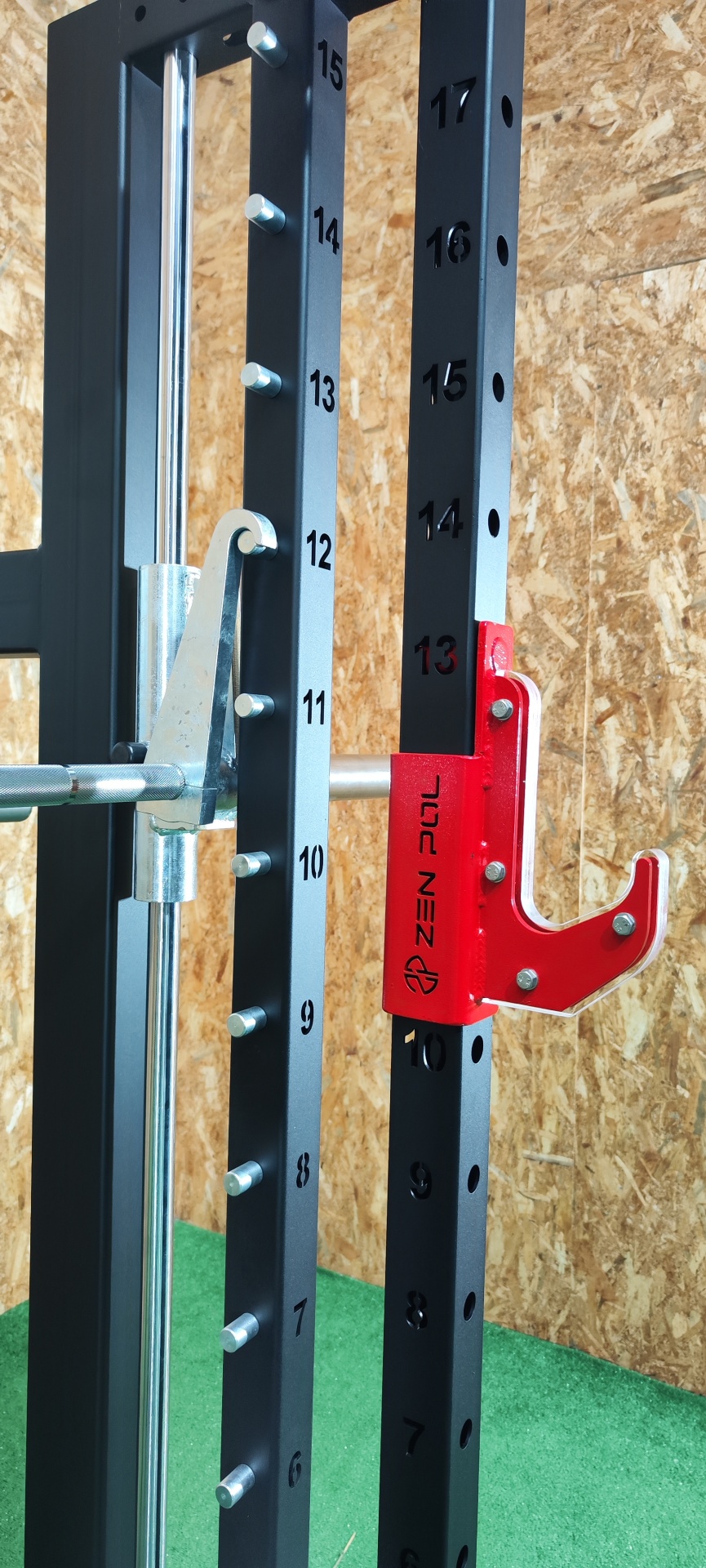 Equipamento de exercício preto e prateado com suporte vermelho marcado com texto ZEN PUL