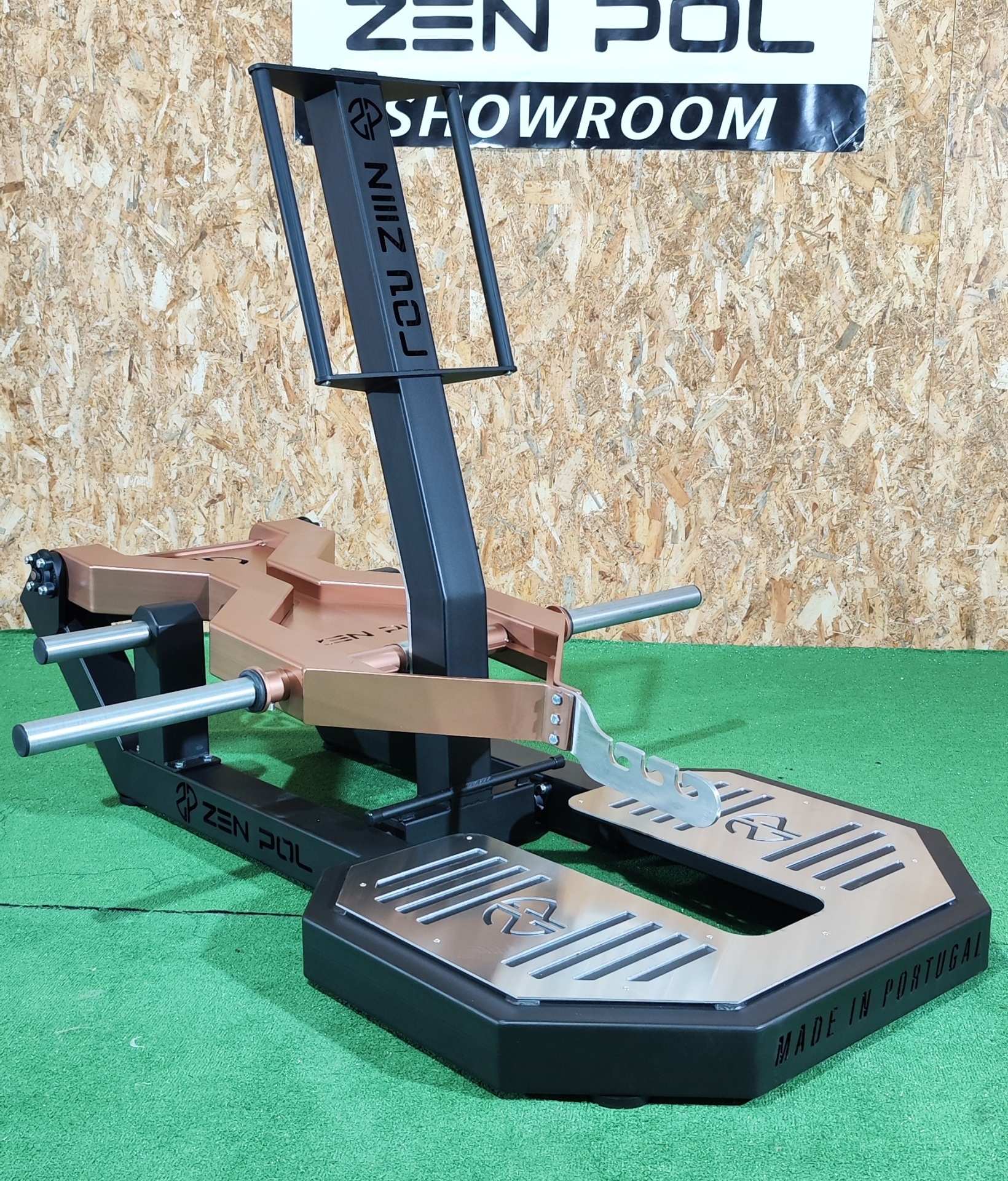 Equipamento de treino de força Zen Pol com base preta e estrutura castanha sobre piso verde