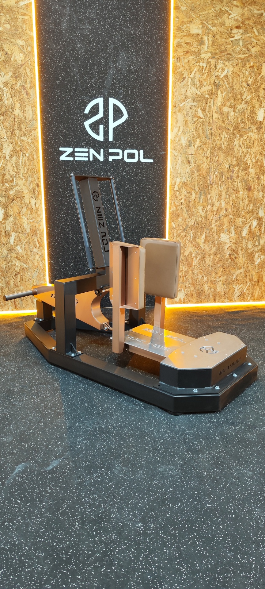 Máquina de exercício metálica preta e castanha com estofos castanhos e logo ZEN POL