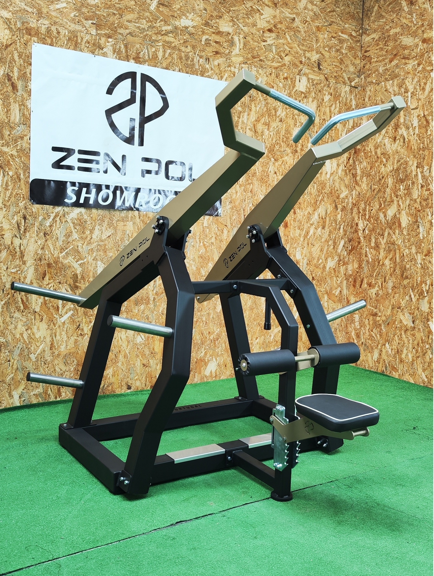 Equipamento de ginásio preto e verde-oliva para treino de costas sobre tapete verde