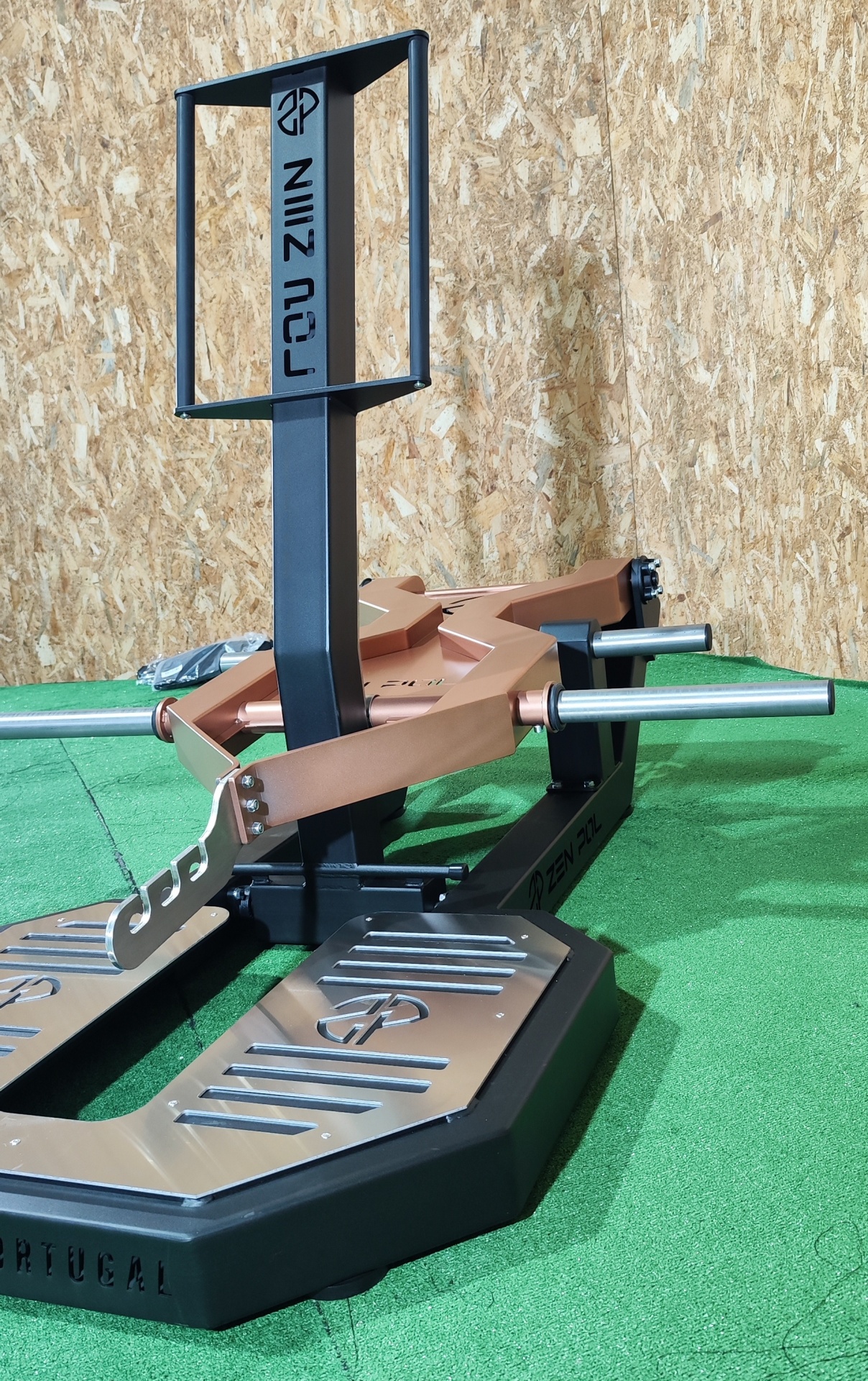 Equipamento de treino de força metálico preto e cobre com texto ROZ ZIIN